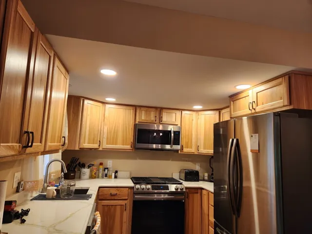 a kitchen with stainless steel appliances granite countertop a refrigerator and a stove top oven