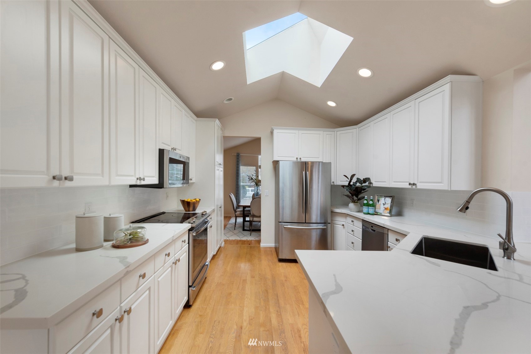 3306 175th Street Southeast Bothell, WA 98012 - Photo 10 of 31 a kitchen with stainless steel appliances a refrigerator sink and white cabinets