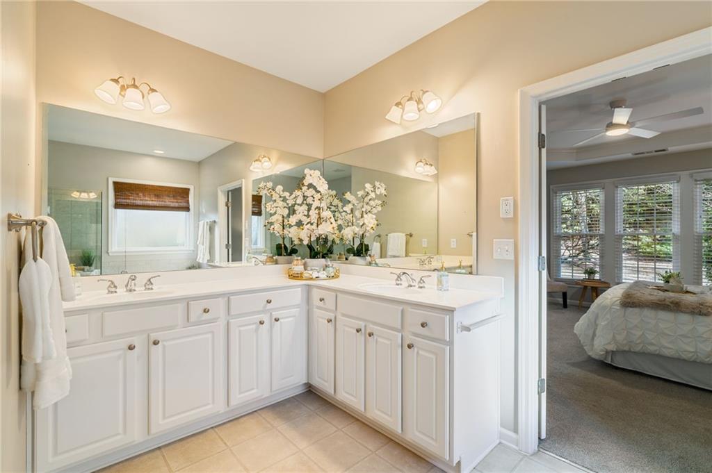 5090 Duke Drive Cumming, GA 30040 - Photo 11 of 65 a spacious bathroom with a granite countertop sink and a mirror