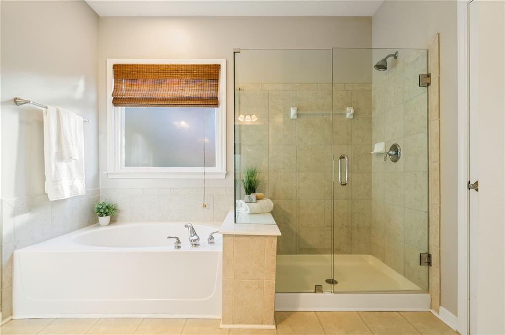 5090 Duke Drive Cumming, GA 30040 - Photo 12 of 65 a bathroom with a bathtub and a shower