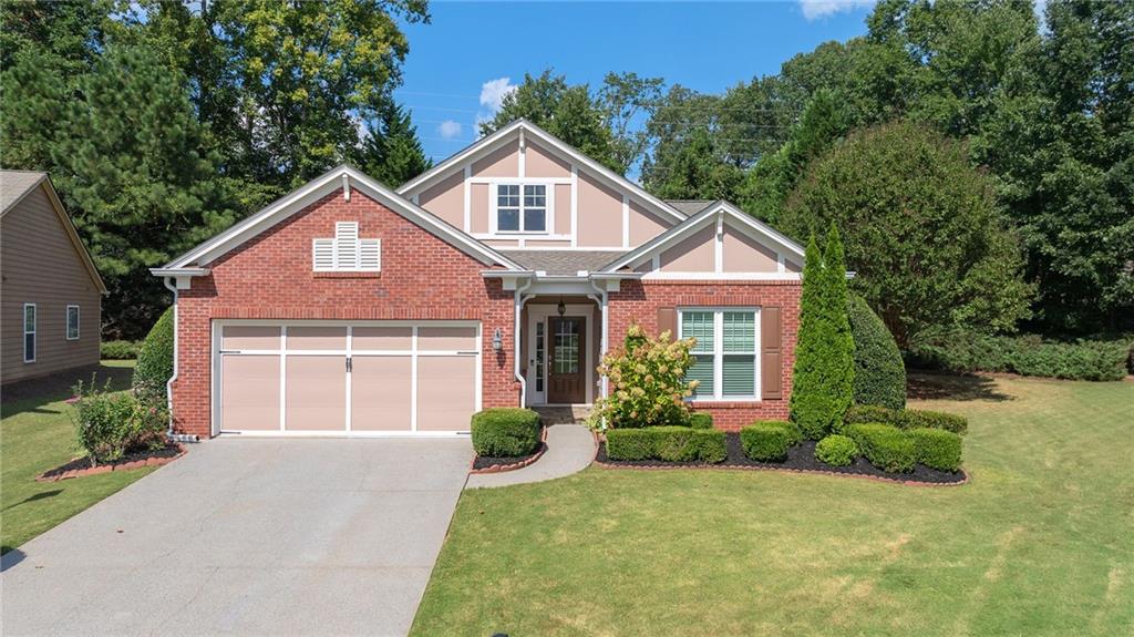 5090 Duke Drive Cumming, GA 30040 - Photo 13 of 65 a front view of a house with a yard and garage