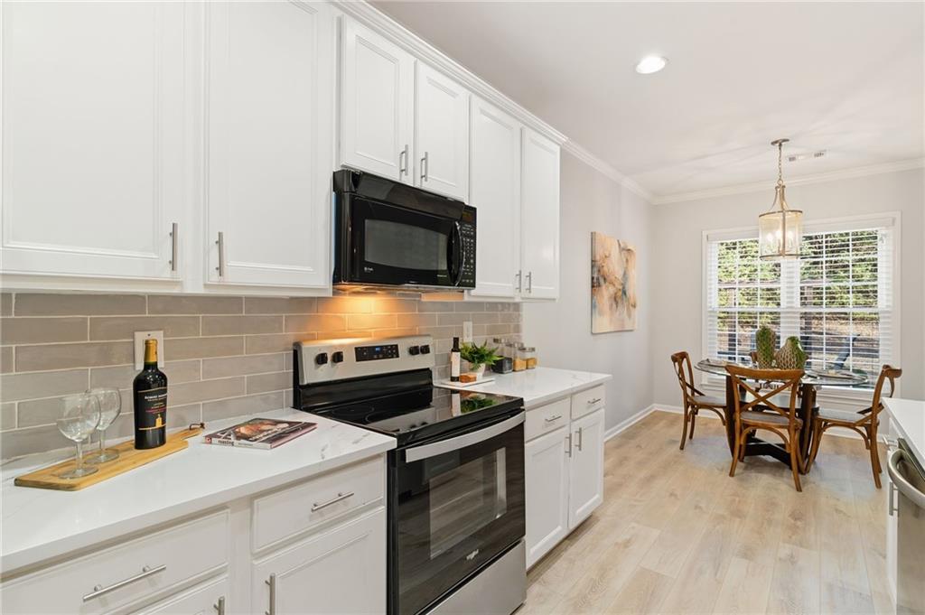 5090 Duke Drive Cumming, GA 30040 - Photo 18 of 65 a kitchen with a stove a sink and a microwave
