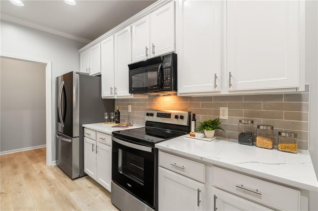 5090 Duke Drive Cumming, GA 30040 - Photo 19 of 65 a kitchen with stainless steel appliances a stove microwave and refrigerator