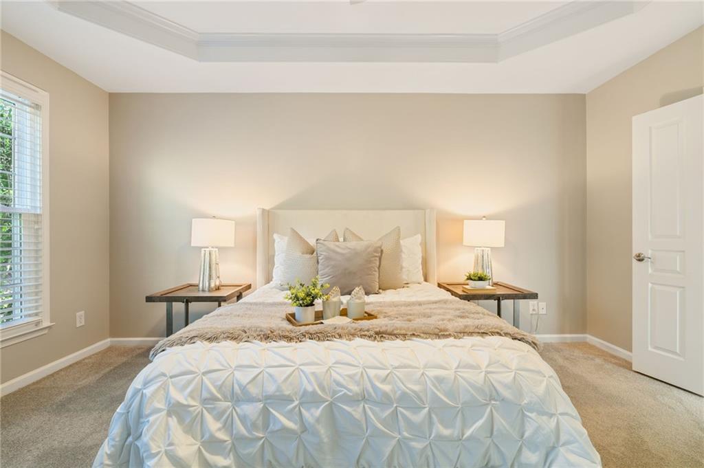 5090 Duke Drive Cumming, GA 30040 - Photo 38 of 65 a large bed sitting in a bedroom next to a window and lamp