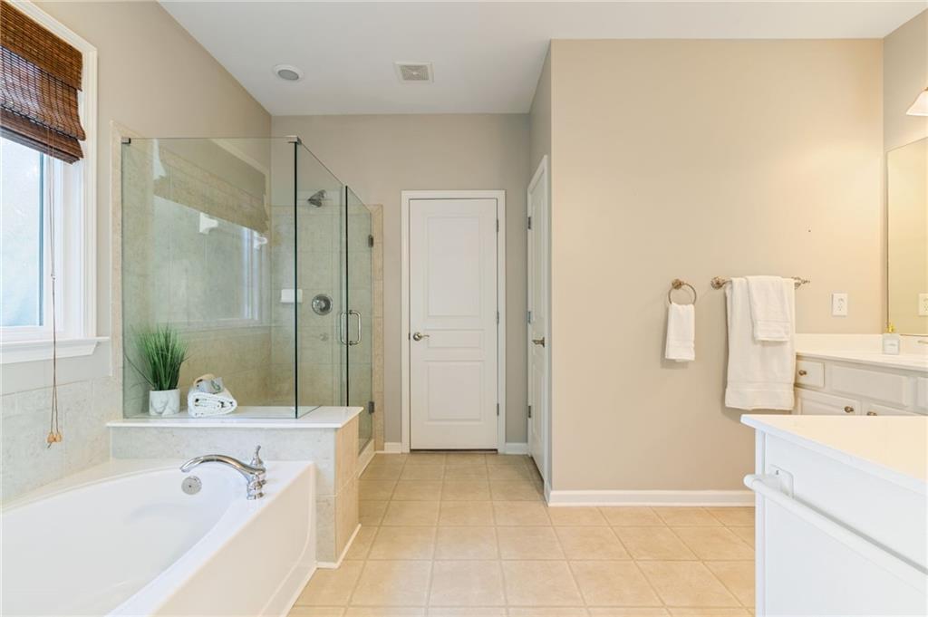 5090 Duke Drive Cumming, GA 30040 - Photo 41 of 65 a bathroom with a tub sink and mirror