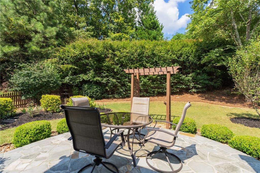 5090 Duke Drive Cumming, GA 30040 - Photo 51 of 65 a view of a patio with table and chairs potted plants with wooden floor and fence