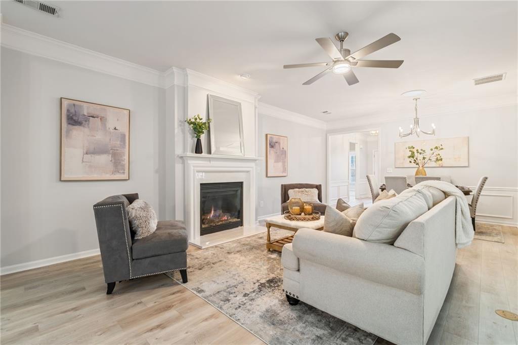 5090 Duke Drive Cumming, GA 30040 - Photo 7 of 65 a living room with furniture a fireplace and a chandelier