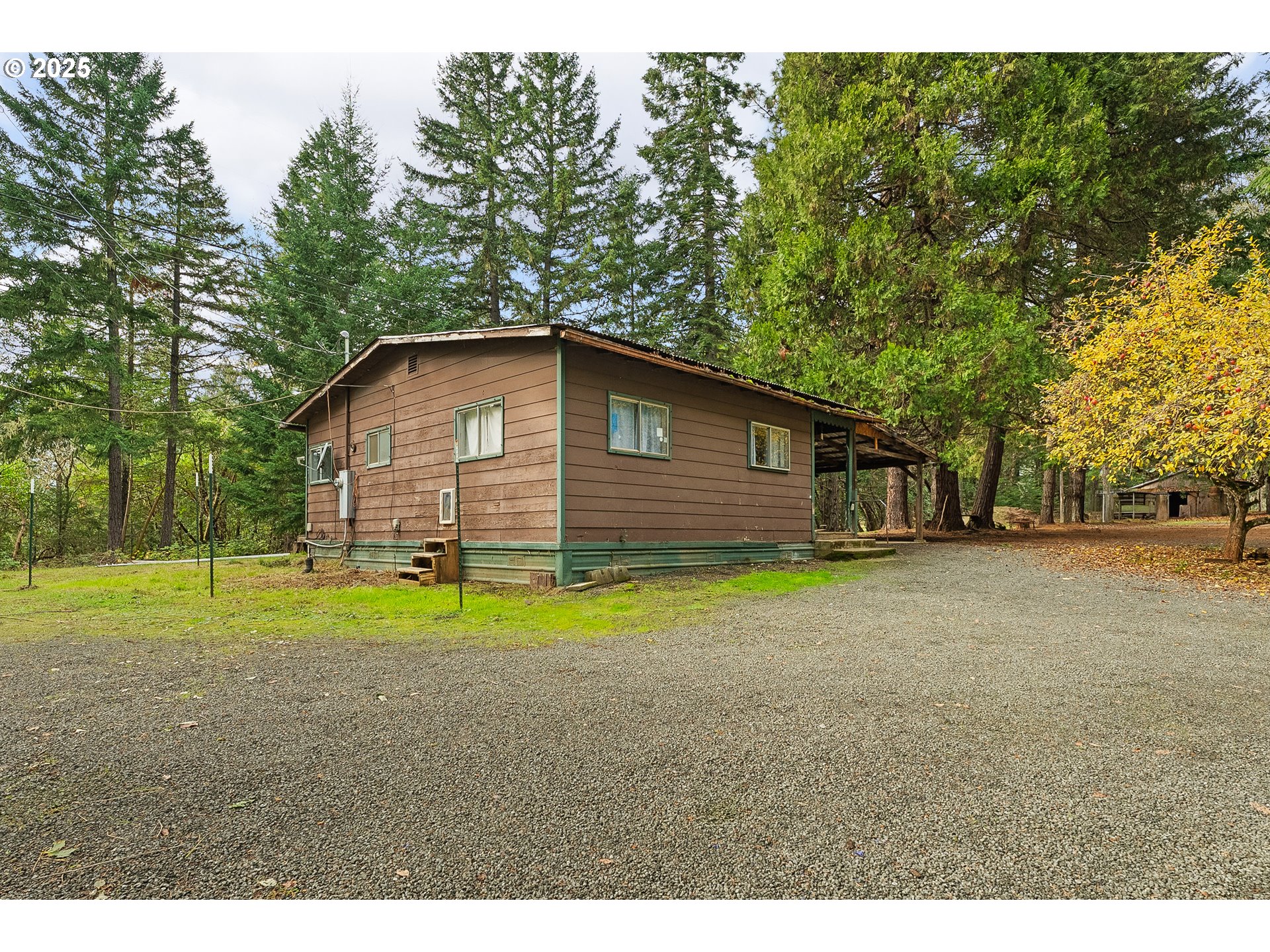 414 Callahan Road Roseburg, OR 97471 - Photo 2 of 33 a backyard of a house with large trees and plants