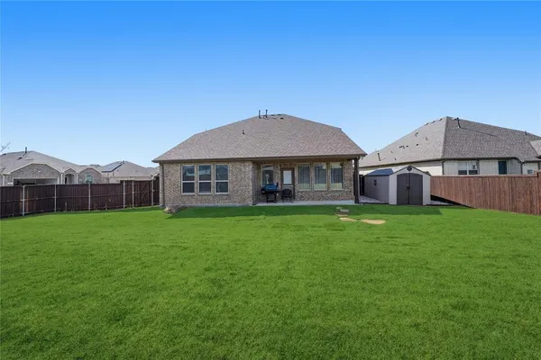 a view of a house with a big yard and large trees