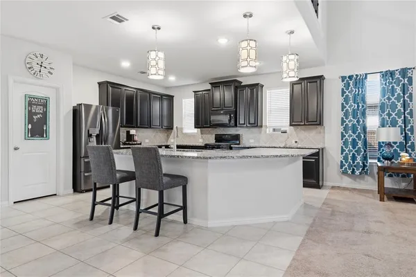a kitchen with a sink and chairs