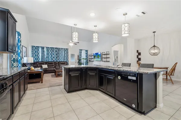 a large kitchen with stainless steel appliances granite countertop a stove top oven a sink and dishwasher