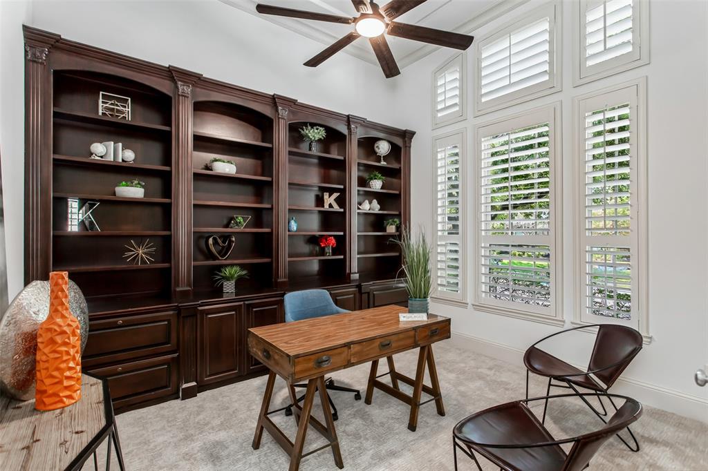 846 Deerfield Road Allen, TX 75013 - Photo 4 of 40 Built-in cabinetry with dark wood finish, multiple window panels with plantation shutters, ceiling fan with integrated lighting, and vaulted ceiling