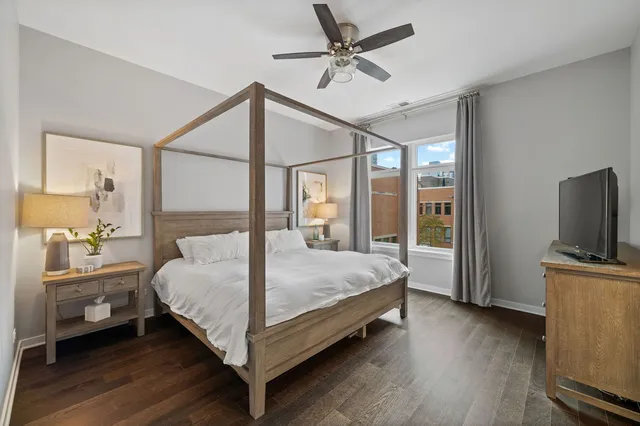 a bedroom with a bed and a flat tv screen on the dresser