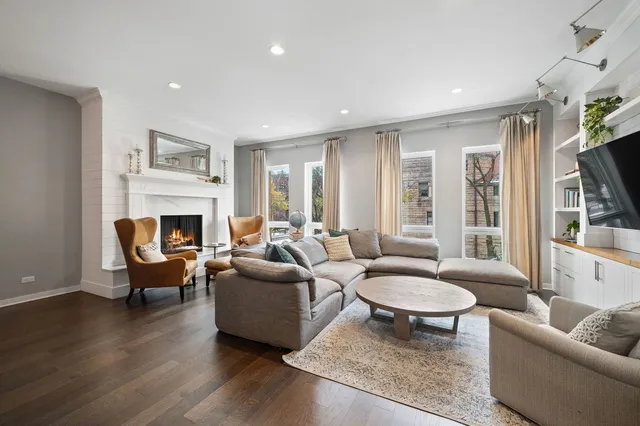 a living room with furniture a rug a fireplace and a flat screen tv
