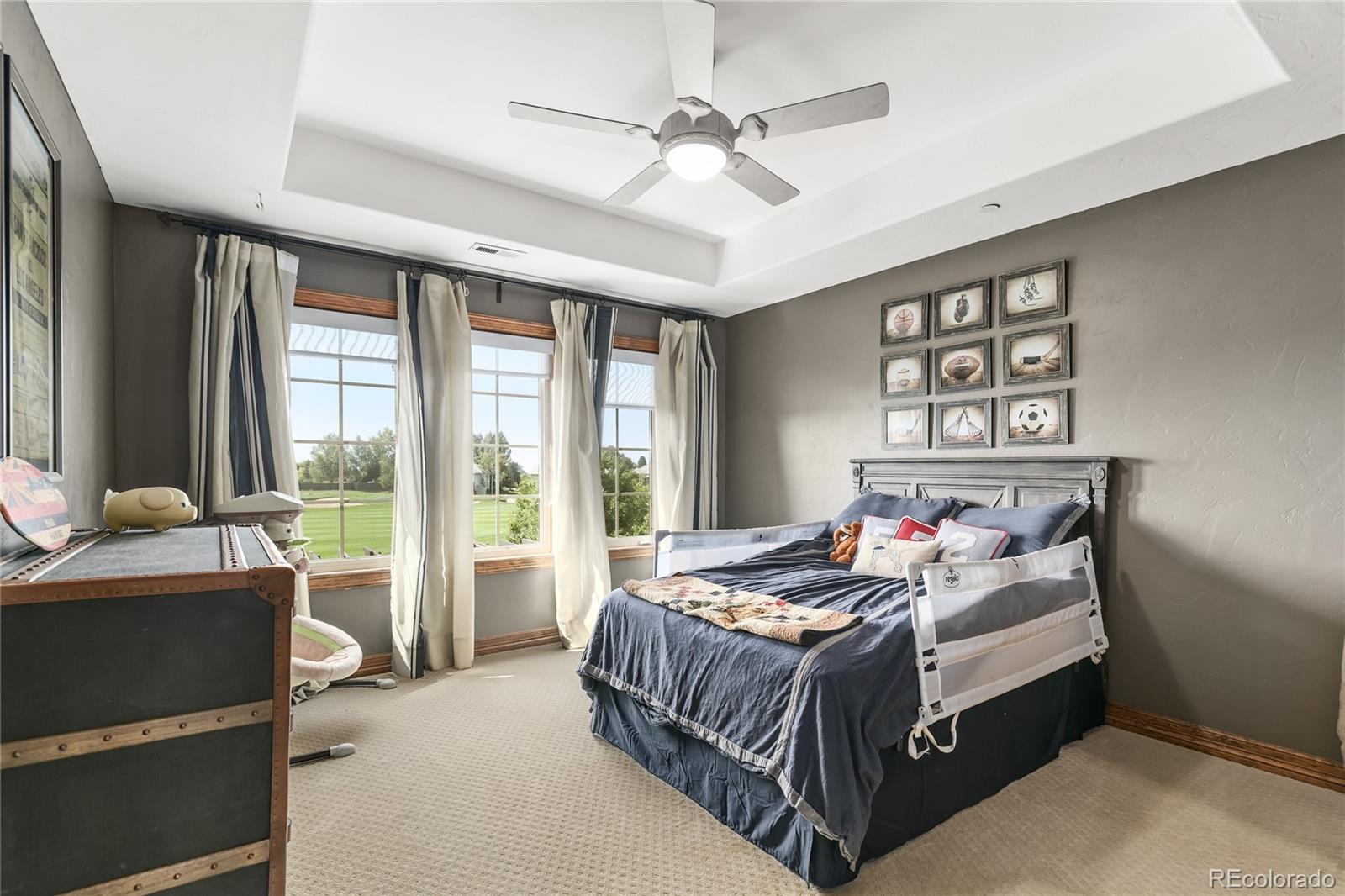 1295 Buffalo Ridge Road Castle Pines, CO 80108 - Photo 18 of 29 a bedroom with a bed and a large window
