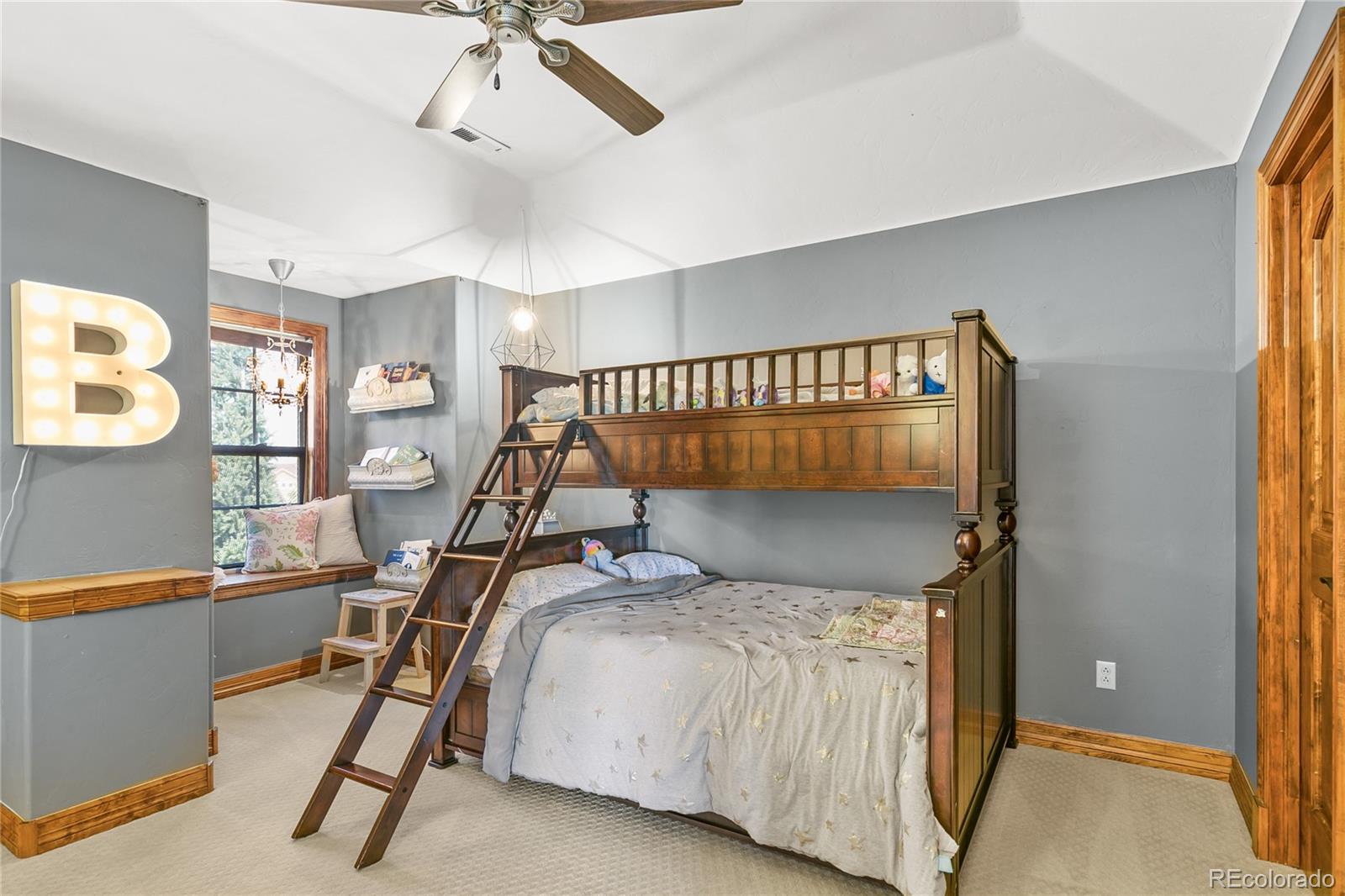 1295 Buffalo Ridge Road Castle Pines, CO 80108 - Photo 19 of 29 a bedroom with a bed and a chandelier