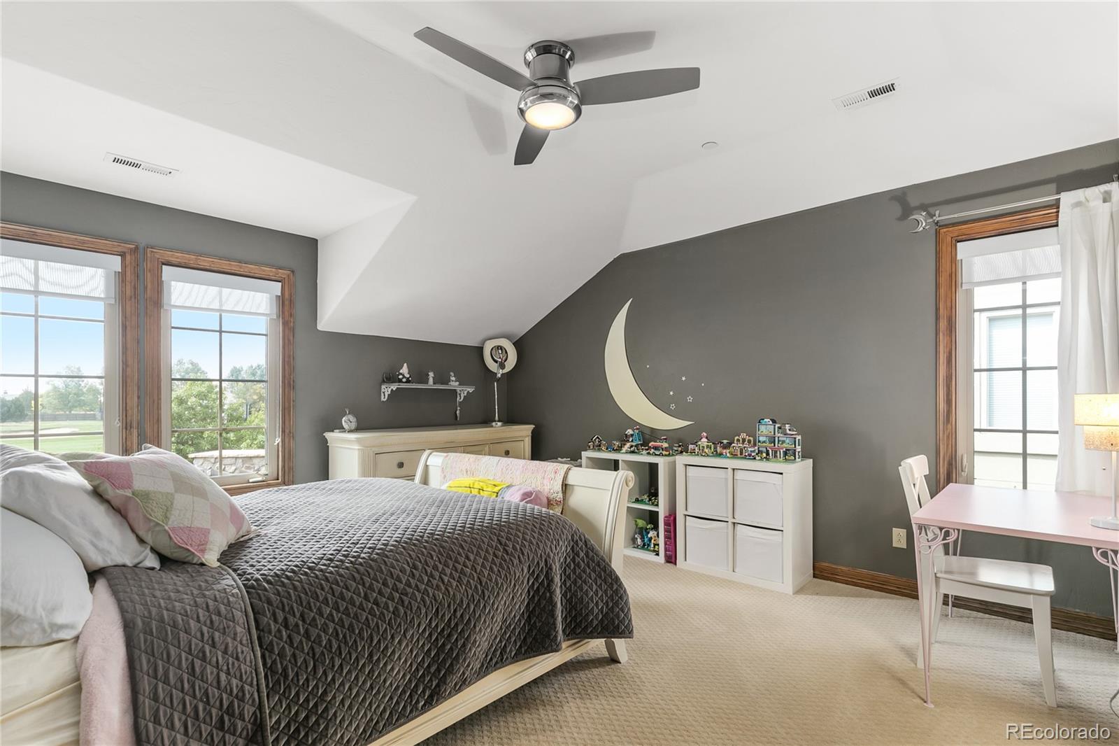 1295 Buffalo Ridge Road Castle Pines, CO 80108 - Photo 20 of 29 a bedroom with a bed a dresser and windows