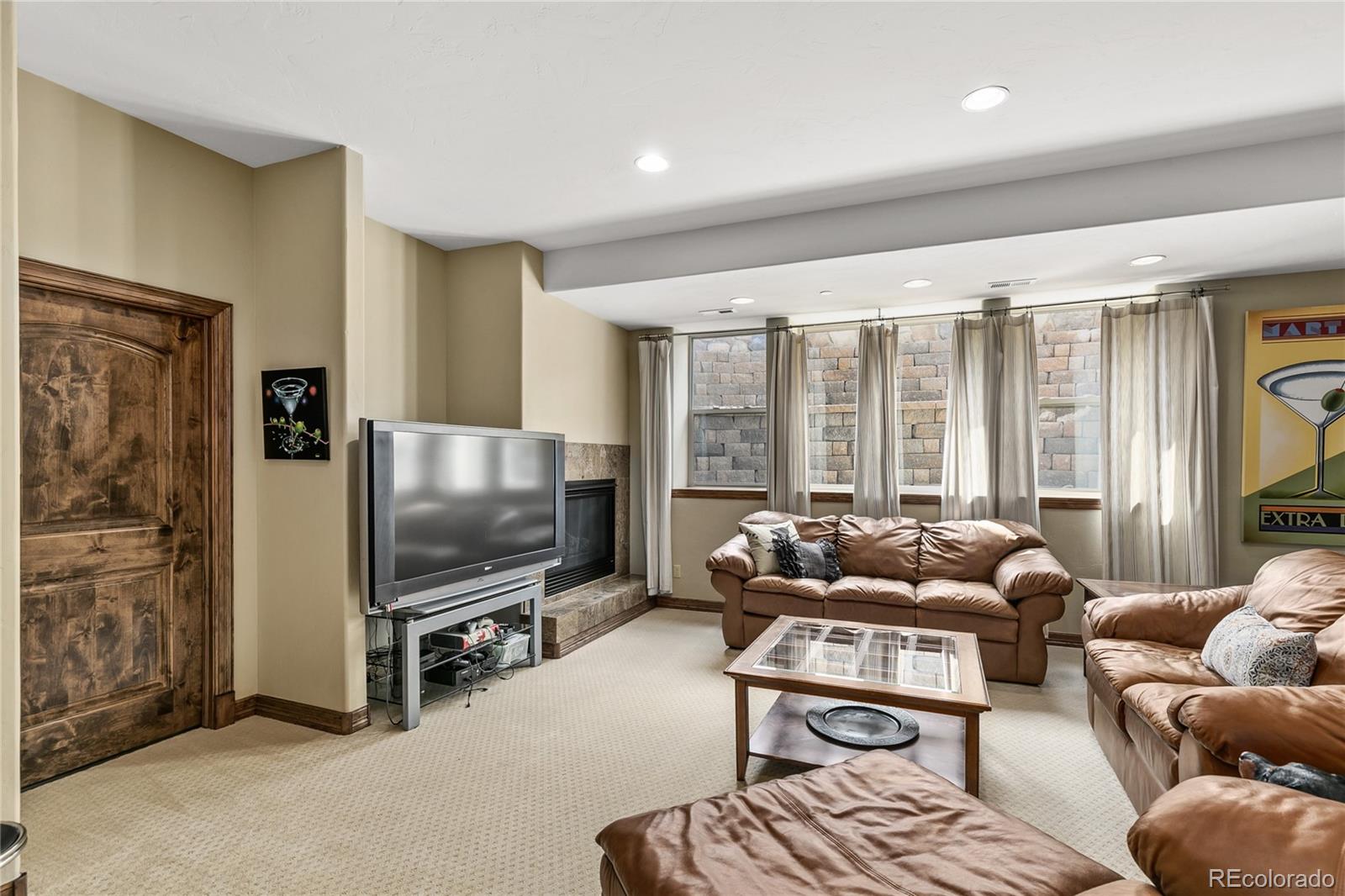 1295 Buffalo Ridge Road Castle Pines, CO 80108 - Photo 23 of 29 a living room with furniture and a flat screen tv