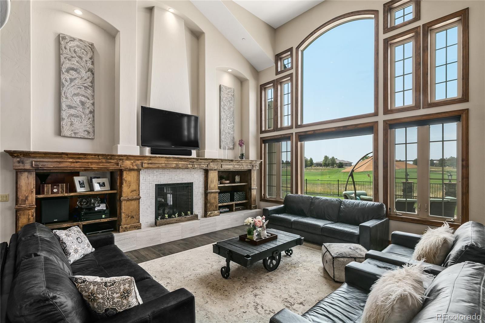 1295 Buffalo Ridge Road Castle Pines, CO 80108 - Photo 6 of 29 a living room with furniture fireplace and a flat screen tv