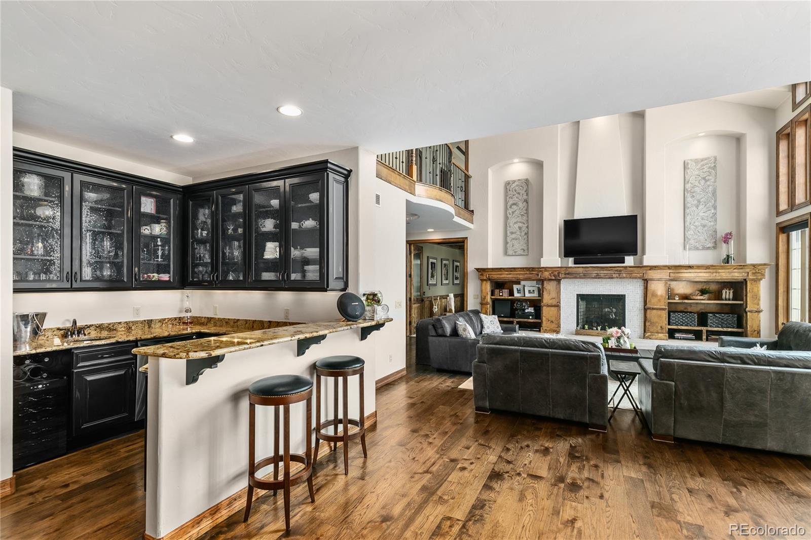 1295 Buffalo Ridge Road Castle Pines, CO 80108 - Photo 8 of 29 a kitchen with stainless steel appliances granite countertop a stove top oven a sink dishwasher a dining table and chairs with wooden floor
