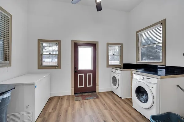 a view of washer and dryer with bathroom in the background