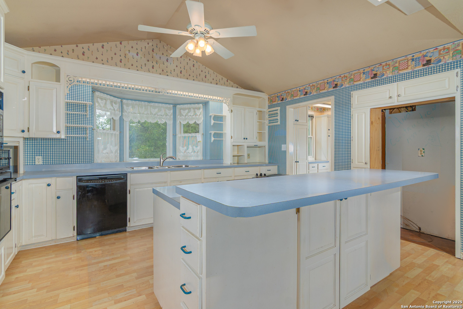 2981 Vivroux Ranch Road Seguin, TX 78155 - Photo 31 of 50 a kitchen with a sink dishwasher a stove and white cabinets with wooden floor
