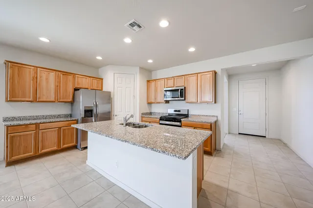 a kitchen with stainless steel appliances granite countertop a stove refrigerator sink and cabinets