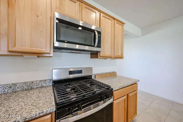 a kitchen with stainless steel appliances granite countertop a stove and a microwave