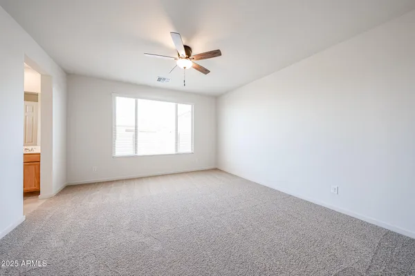 an empty room with windows and fan