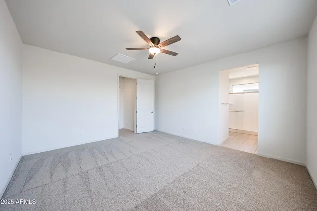 a view of an empty room with a ceiling fan