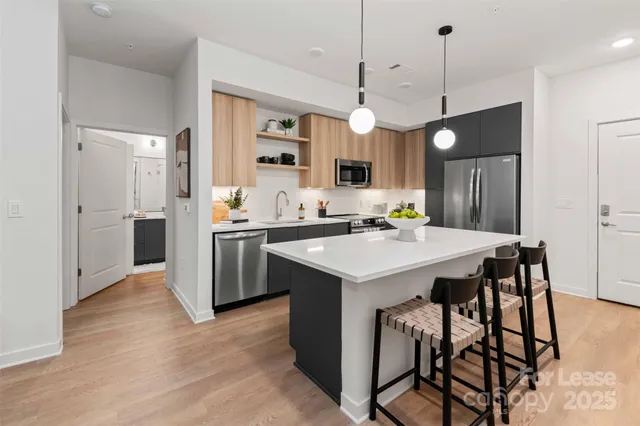 a kitchen with kitchen island a stove a table a sink refrigerator and cabinets