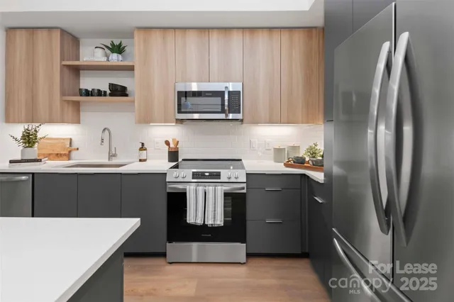 a kitchen with stainless steel appliances a stove microwave sink and refrigerator