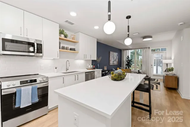 a kitchen with stove and chairs
