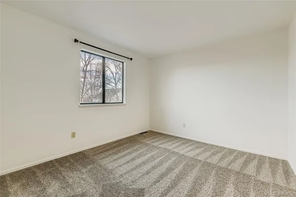 an empty room with windows and closet