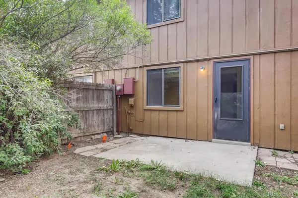 a view of a backyard with large trees and wooden fence