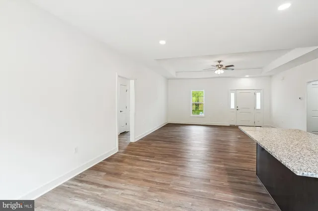 a large kitchen with stainless steel appliances granite countertop a large counter top a stove and a wooden floors