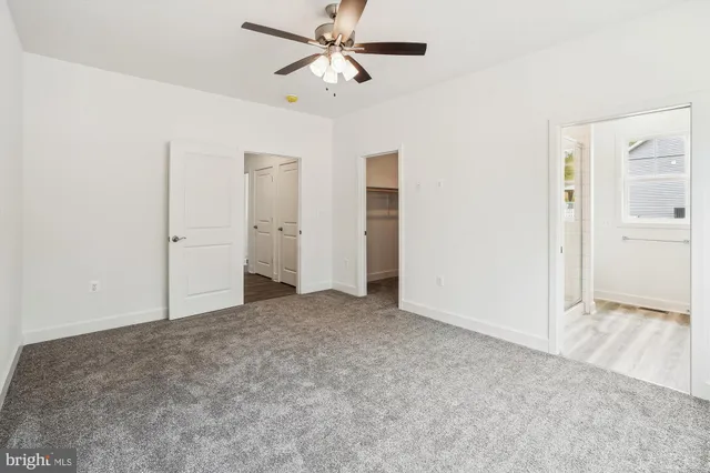 an empty room with a window and a ceiling fan