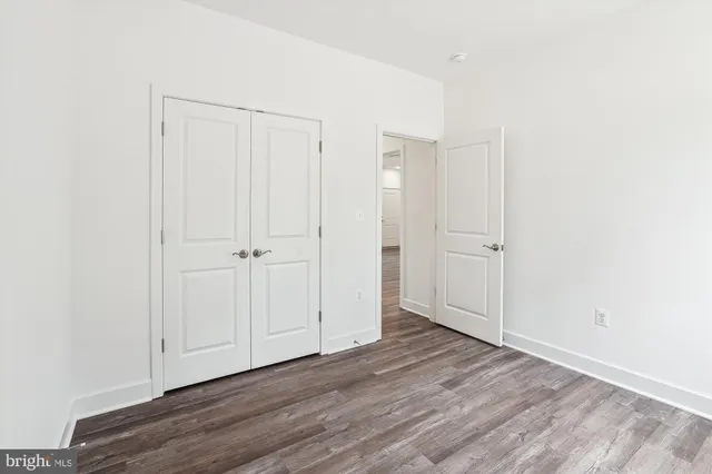 an empty room with wooden floor and window
