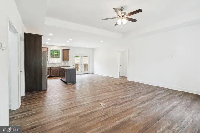 a large kitchen with kitchen island granite countertop a sink refrigerator and cabinets