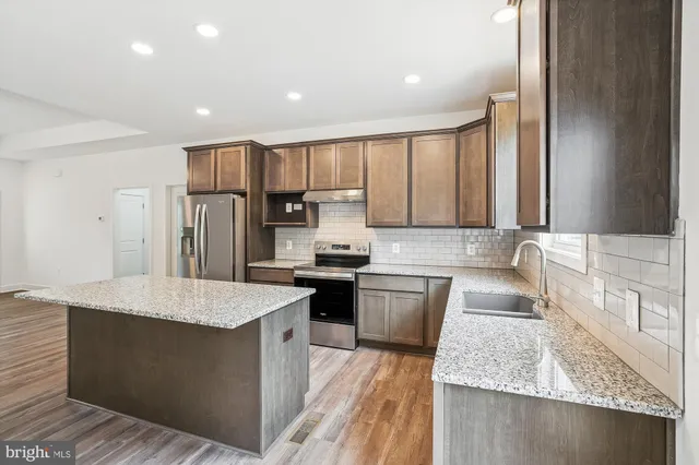 a view of a kitchen with a refrigerator and a stove top oven