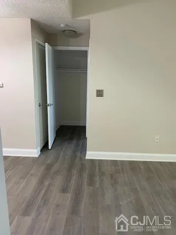 an empty room with wooden floor and closet