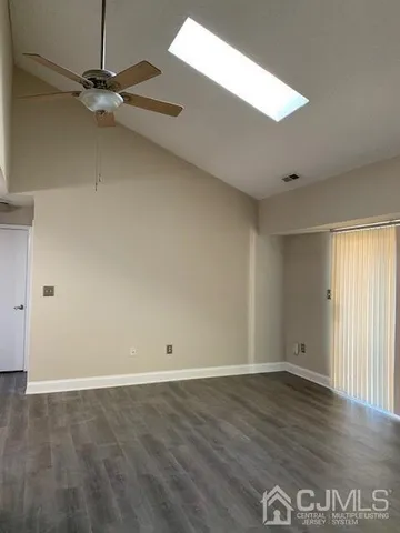 an empty room with wooden floor and a window