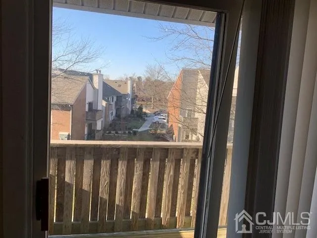 a view of a glass door with a balcony from a window