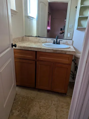a bathroom with a granite countertop sink and a mirror