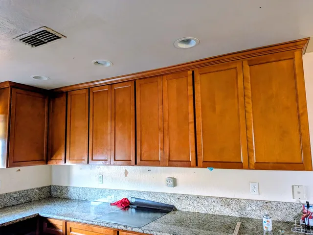 a kitchen with granite countertop wooden cabinets
