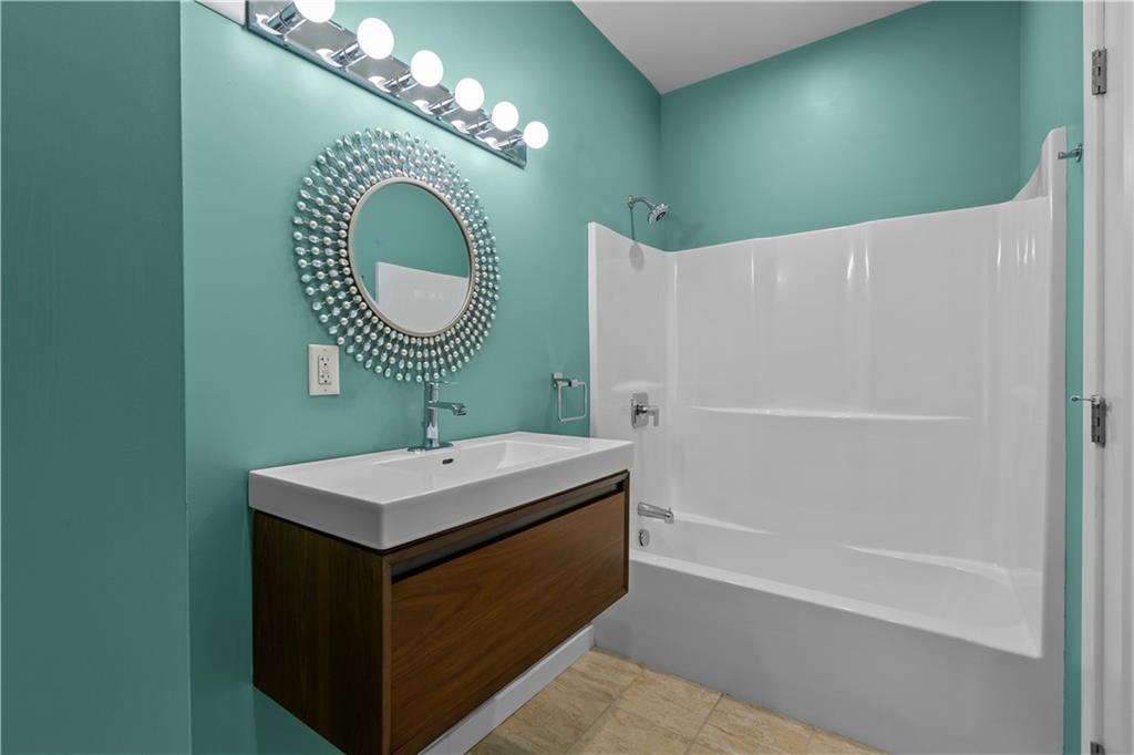 1825 Arcena Street, Unit 3 Pittsburgh, PA 15219 - Photo 17 of 31 a bathroom with a sink a toilet and a mirror