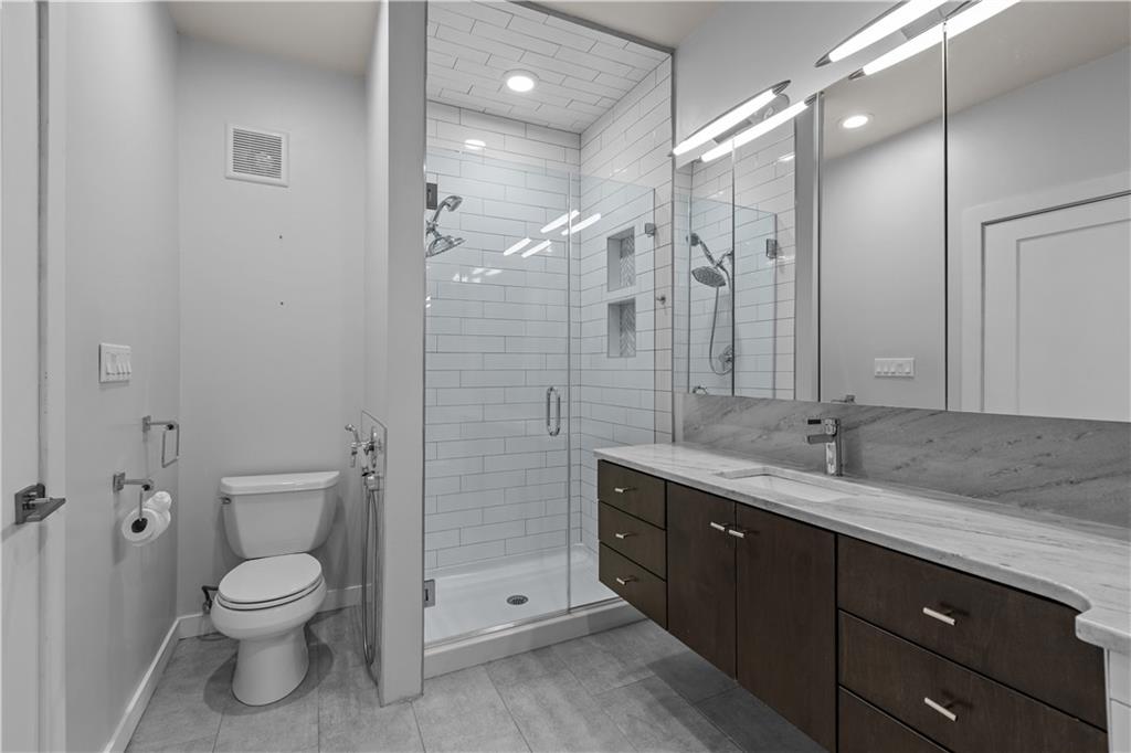 1825 Arcena Street, Unit 3 Pittsburgh, PA 15219 - Photo 22 of 31 a bathroom with a granite countertop toilet a sink and a mirror