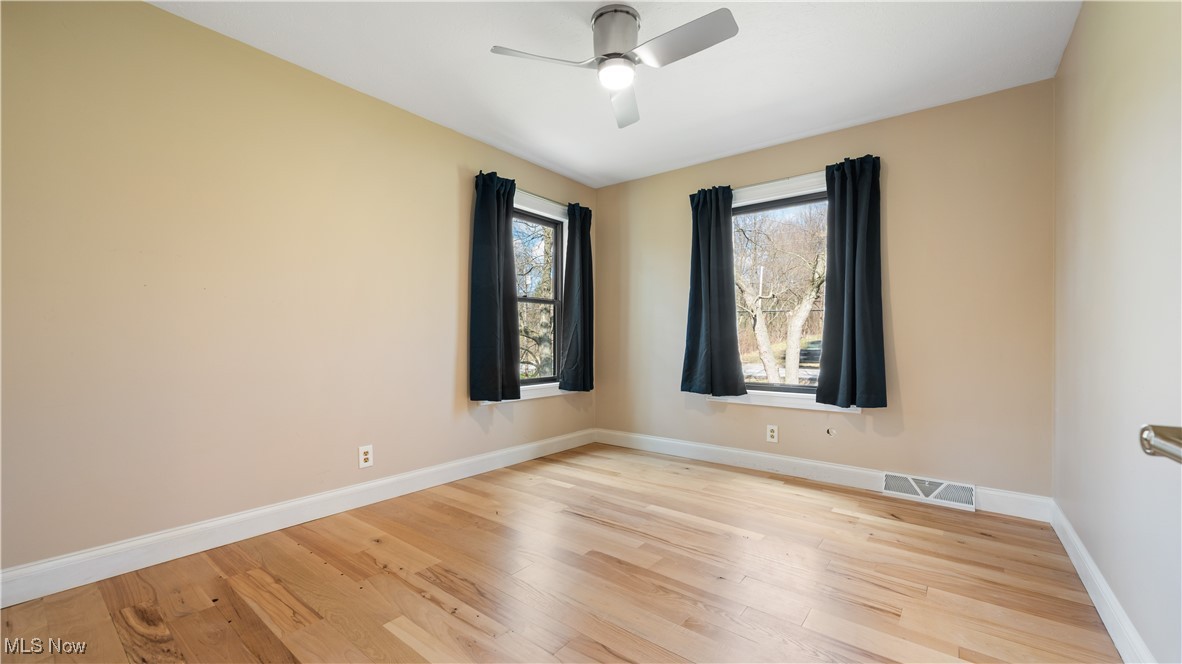8410 Shepard Road Macedonia, OH 44056 - Photo 25 of 34 Spare room with wood finished floors, visible vents, baseboards, and ceiling fan