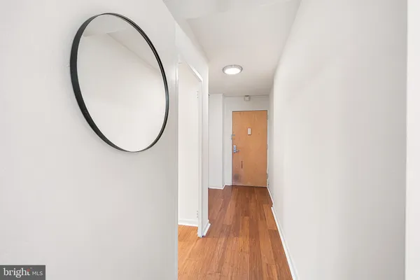 a view of a livingroom with wooden floor and a mirror