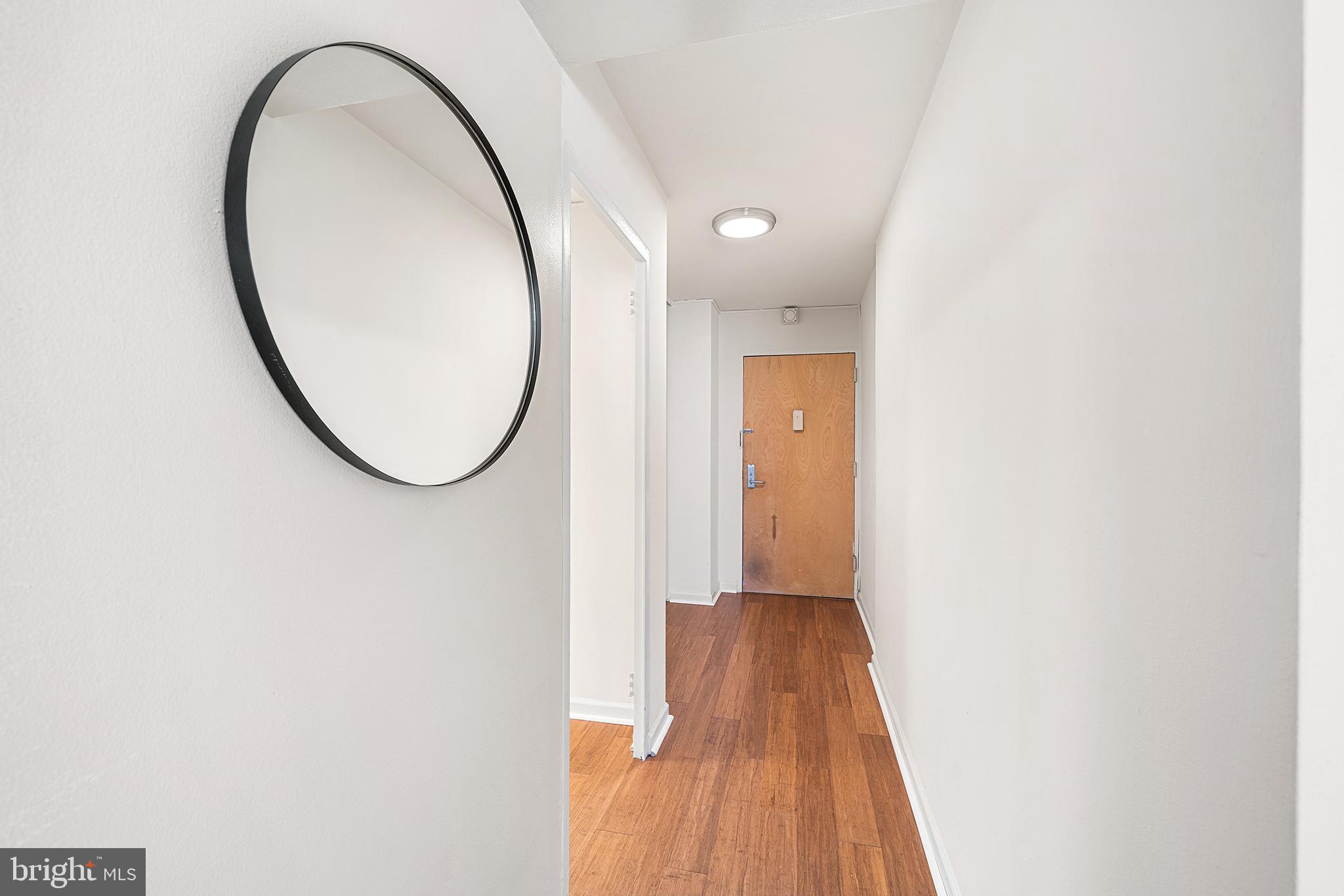 604 South Washington Square, Unit 2606 Philadelphia, PA 19106 - Photo 21 of 37 a view of a livingroom with wooden floor and a mirror